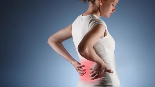 Woman holding her back in pain